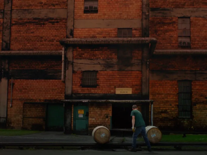 Barrels rolled along the loading dock of a brick bonded rickhouse